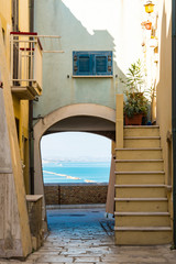Small alley with stairs, gate and view on the Adriatic Sea. Termoli, Italy
