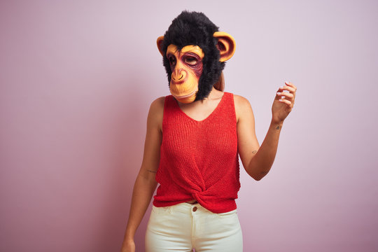 Woman standing wearing t-shirt and monkey mask