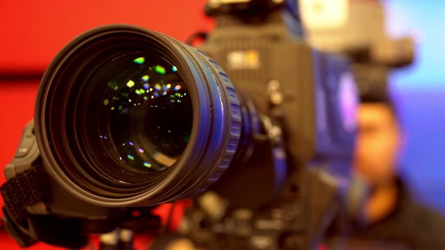 Cameraman in process of work in studio. Camera Lens