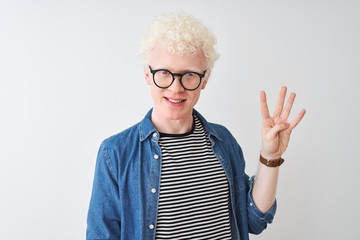 Young albino blond man wearing denim shirt and glasses over isolated white background showing and pointing up with fingers number four while smiling confident and happy.