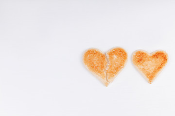 Bread toast broken heart with whole heart together on white background. The concept of divorce, breakup, unhappy relationship. Copy space.