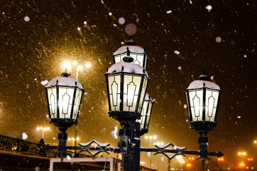 Lantern with five lights in a snowstorm at night in winter.