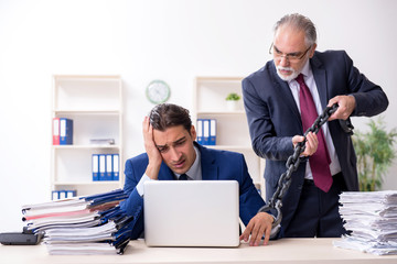 Old boss and young male employee in the office