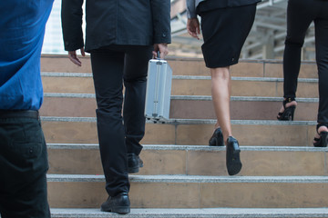 businessman legs walking the stairs in modern city.