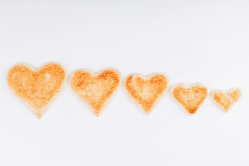 Group of toasted bread hearts with one broken heart together on white background. The concept of unhappy and misunderstanding in big family.