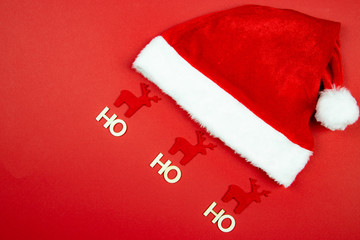 Święty Mikołaj i czapka wraz z reniferami na czerwonym tle - obrazy, fototapety, plakaty