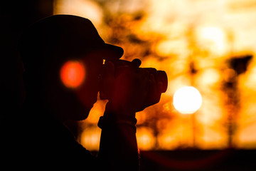silhouette man photographing at sunset