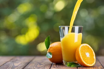 Rolgordijnen orange juice pouring in glass © alter_photo