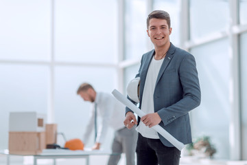 smiling architect standing in a bright office.