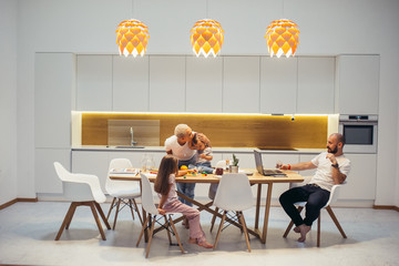 United caucasian family at home in kitchen. Background white interior of kitchen, minimalism. Children, happiness, home