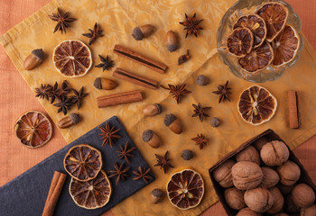 Beautiful festive composition of dried fruits and spices on a beautiful background with utensils with nuts, dried lemons, peanuts, almonds and acorns decorated with decor.