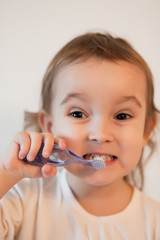 Little cute girl smailing and brushing her teeth.
