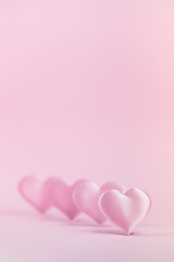 Pink silk heart on a pink background is standing in line. The concept of minimalism. Place for text. Pastel colors .