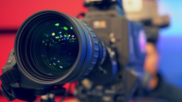 Cameraman in process of work in studio. Camera Lens