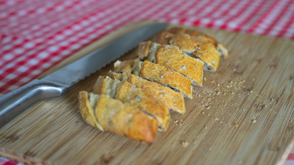 Rebanas de pan y cuchillo de sierra sobre tabla de madera