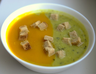 zucchini and melon soup with croutons in white plate