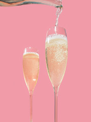 Filling a flute with Prosecco, pink background, in pop contemporary style
