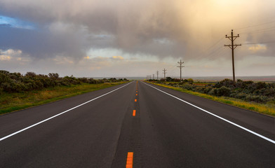 The road goes to the horizon against the background of the evening cloudy sky.