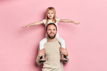blonde beautiful girl with outstretched arms having a rest on her father s shoulder, girl playing a plane with a dad,interest, pastime