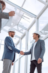 architects and engineers shaking hands in a new building.