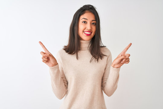 Beautiful chinese woman wearing turtleneck sweater standing over isolated white background smiling confident pointing with fingers to different directions. Copy space for advertisement