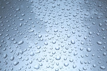 Fototapeta na wymiar Water drops on a shiny paint surface of a car