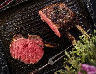 Grilled piece of meat with bone in a grill pan. Fried steak. Roasting - Medium Rare