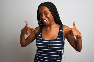 Young african american woman wearing striped t-shirt standing over isolated white background...