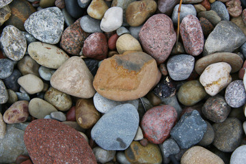 smooth colorful pebbles on the beach background
