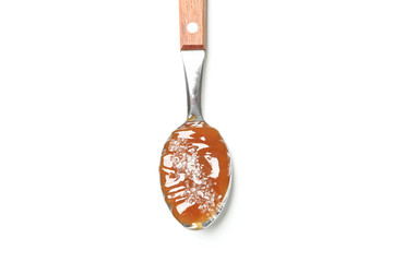 Spoon with salted caramel isolated on white background