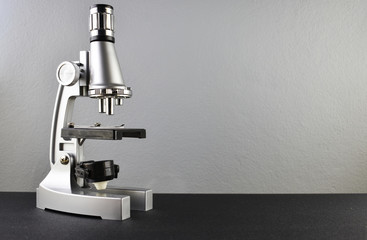 microscope isolated. on black surface, gray background. free space for message or writing
