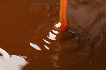 Pouring brown caramel textured background, close up