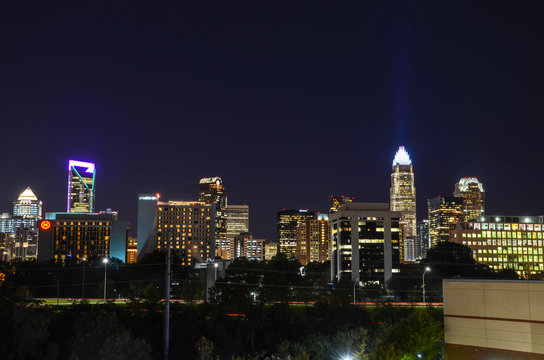 View of Charlotte NC skyline at night. The buildings are illuminated on the night sky.