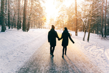 Couple Holding Hands Walking Away. Winter, Sunny, Forrest, Recreation, Leisure, Clothing.