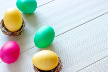 Easter eggs painted in pastel colors on a white wooden background.