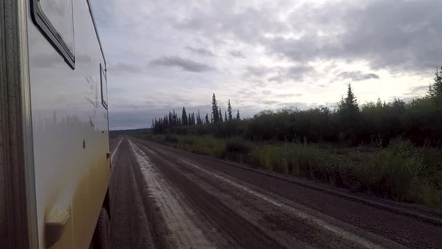 Low side shot of a commercial truck driving on mud in the Dempster Highway in Canada.