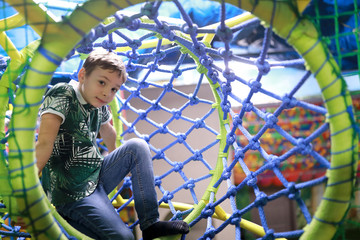 Child sitting in rope maze