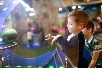 Child throws ball into ring