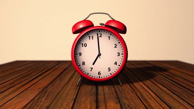 Beautiful alarm clock alarm with bells on the top on a retro wooden background. The hammer hits the bells at seven o`clock