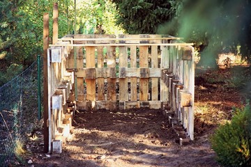 punch. handwork. place for new fertilizer. A new wooden composter stands in the garden by the fence.