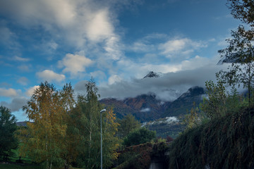 mountain panorama with first snowfall, clouds and fog