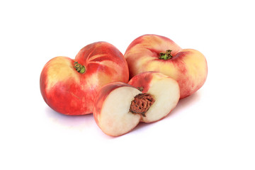 Two flat fig peaches with a half isolated on white