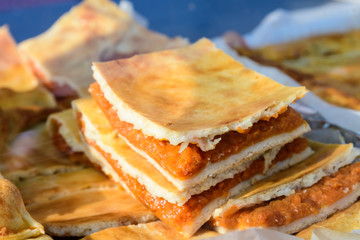 Freshly cooked traditional pumpkin pie in display for sale at a weekend street food market in...