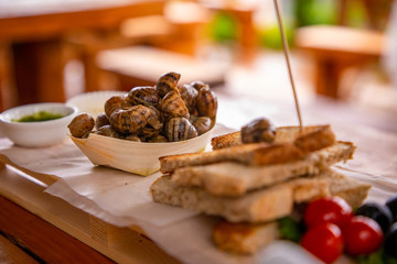 Grilled nails with herbs butter, tomatoes and bread on wooden platter