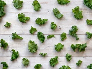 Fresh green kale leaves on white wooden background. Top view or flat lay. Curve kale leaves...