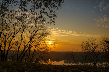 Obraz premium Dawn in the park, a sunlit alley, trees and a bench.
