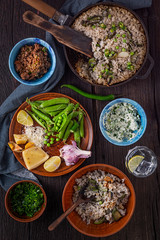 Vegetarian food. Rice with green vegetables or vegetarian paella on a wooden table