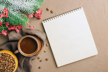 Christmas composition from notebook, pen, coffee cup and fir dranches on wooden background, place for text. Christmas, winter, new year concept. Flat lay, top view, copy space