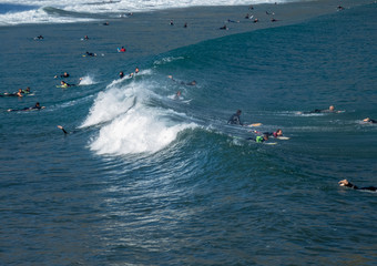 Islares, Spain , 29 September 2019 Wide surf beach of Islares with surfers riding through  waves in Cantabria, Spain.