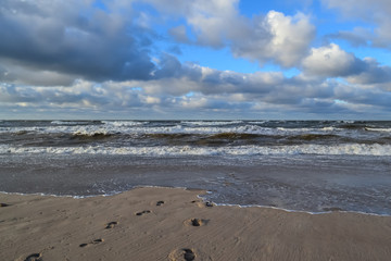 beautiful clouds over the sea beach footprints in the sand